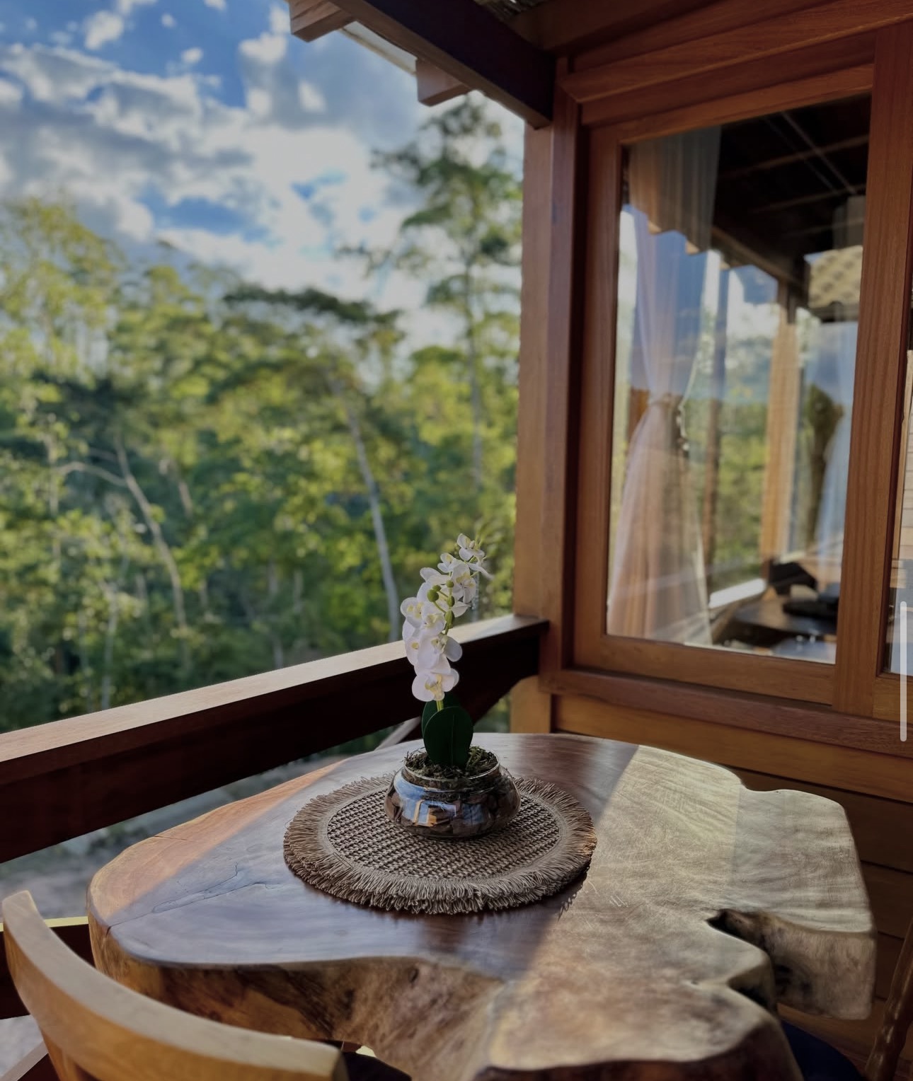 Mesa de madeira na varanda com vista para a mata